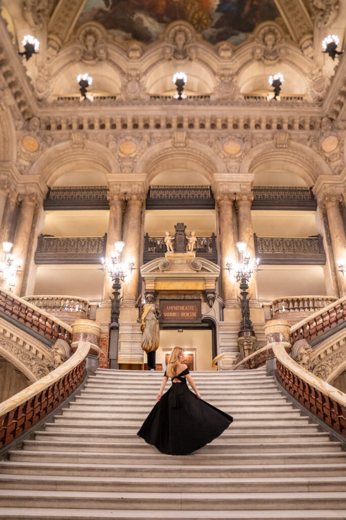 Palais Garnier interior staircase Paris photoshoot location with a woman in a black dress