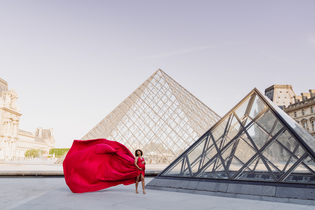 Louvre Pyramid photoshoot in Paris, flying red dress movement at the museum courtyard