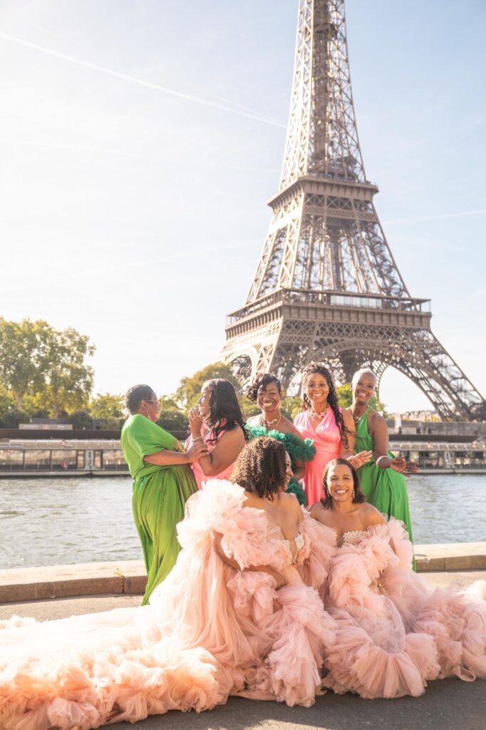 Paris Group Photoshoot with flying dresses, seven women posing in colorful gowns