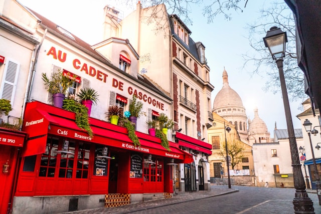 Montmartre streets Paris photoshoot location with a classic red café and Sacré-Cœur view
