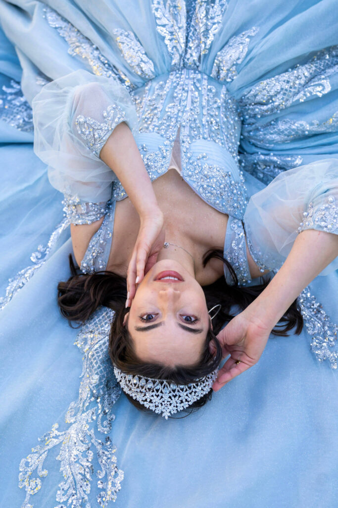 Artistic quinceanera portrait in a light blue princess dress with sparkling tiara